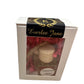 Glass bottle car diffuser labeled "Caramel Apple" with a wooden cork. Packaged with pink and red decorative shredded paper inside a box with a window. Branded "Everlee Jane". Available size: Small.