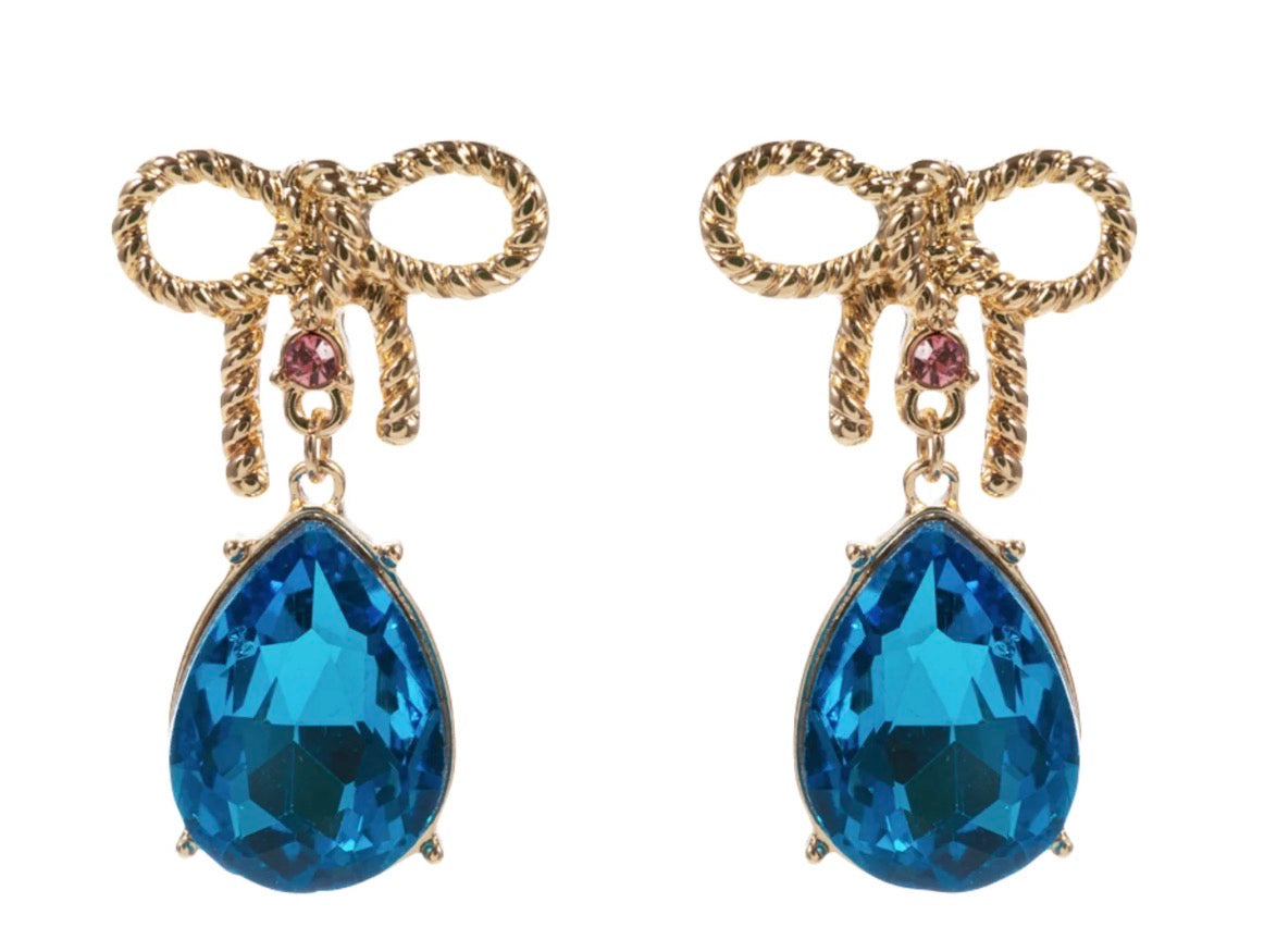 Gold bow earrings with a small pink gem and a dangling large blue teardrop gem, available in small, medium, and large sizes.