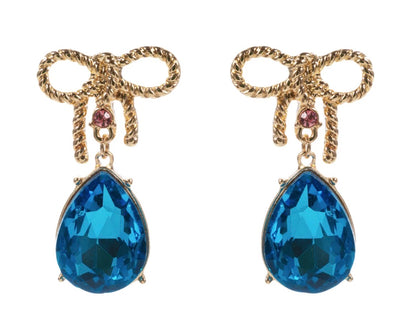 Gold bow earrings with a small pink gem and a dangling large blue teardrop gem, available in small, medium, and large sizes.