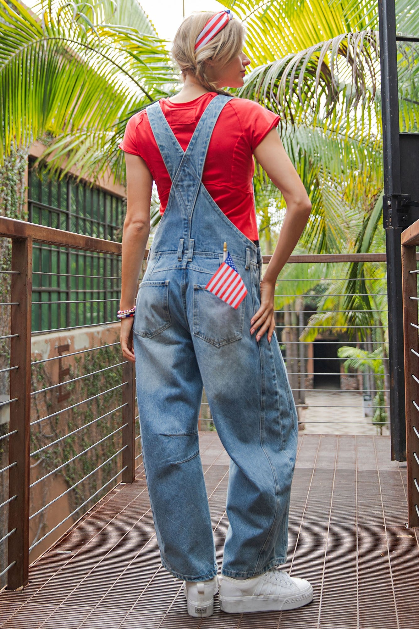 Dakota Mineral Wash Denim Jumpsuit with barrel leg cut and American flag patch on the back pocket. Available in sizes XS–XL.