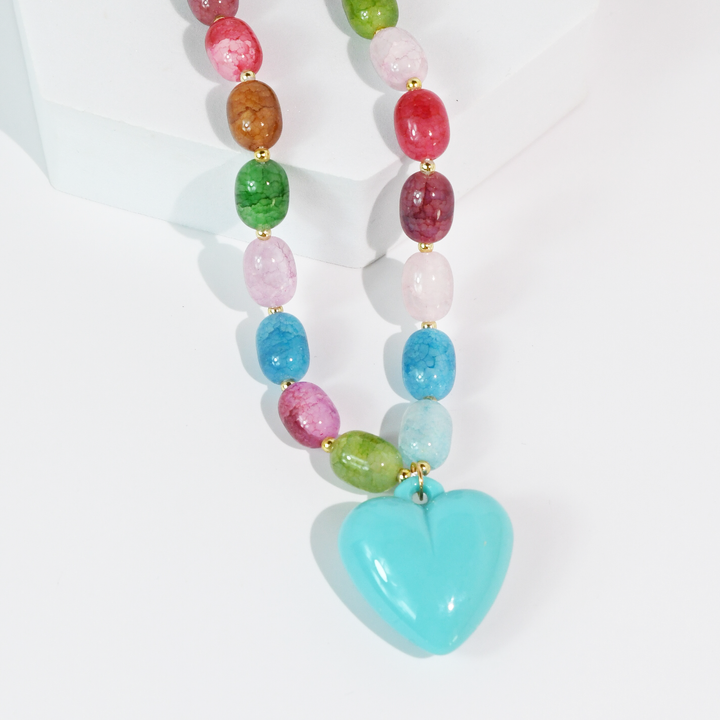 Oval beads in various colors with a turquoise heart pendant. Available in two sizes.