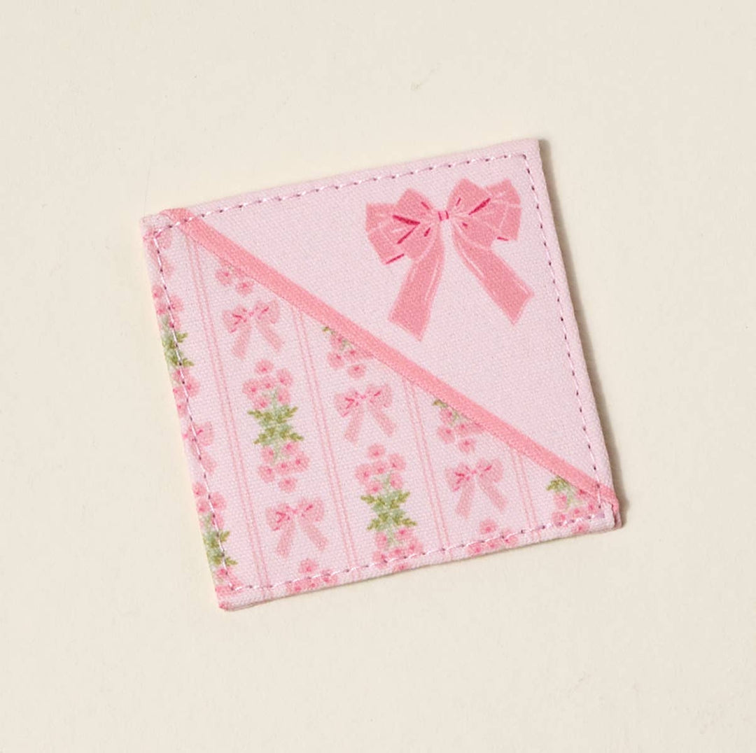 Small, square quilted bookmark with pink roses, green leaves, bows, and floral accents. Size: small.
