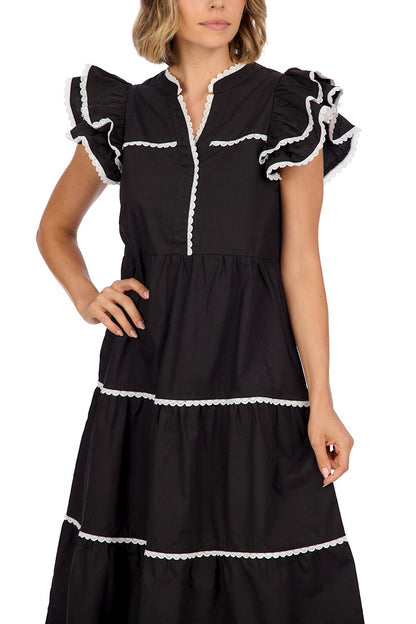 The Pia Ric Rac Midi Dress is an elegant cotton poplin outfit with white lace trim, ruffled short sleeves, and a tiered design featuring contrasting white edging. Available sizes: XS, S, M, L, XL.