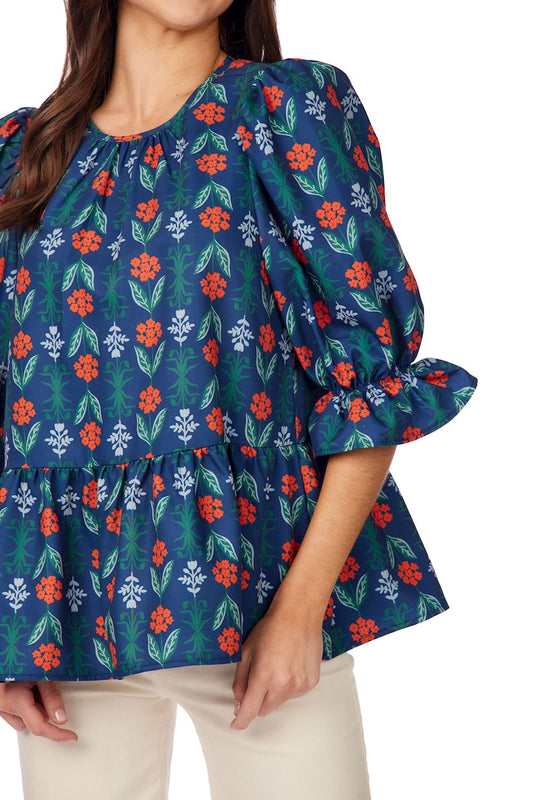 Navy Floral Pierce Flounce Top: blue floral blouse with puffed ruffle sleeves and peplum waist. Sizes XS–XL.