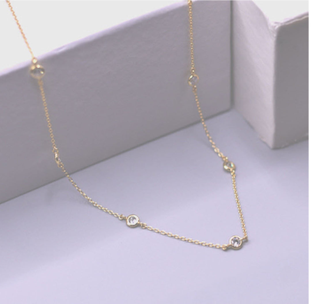 The Bloom Gold Necklace: delicate adjustable gold chain with evenly spaced small round clear gemstones. Available in multiple sizes.