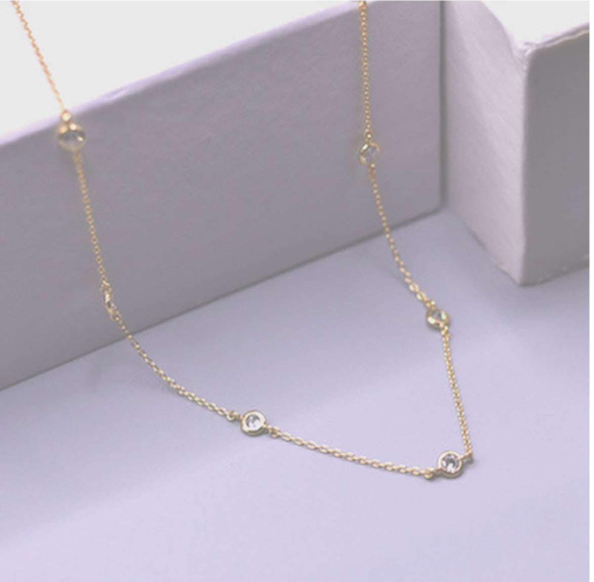 The Bloom Gold Necklace: delicate adjustable gold chain with evenly spaced small round clear gemstones. Available in multiple sizes.