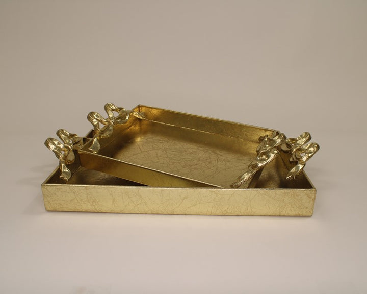 Two rectangular gold metal trays with bow handles and a shiny, textured finish. Available in two stacked sizes.