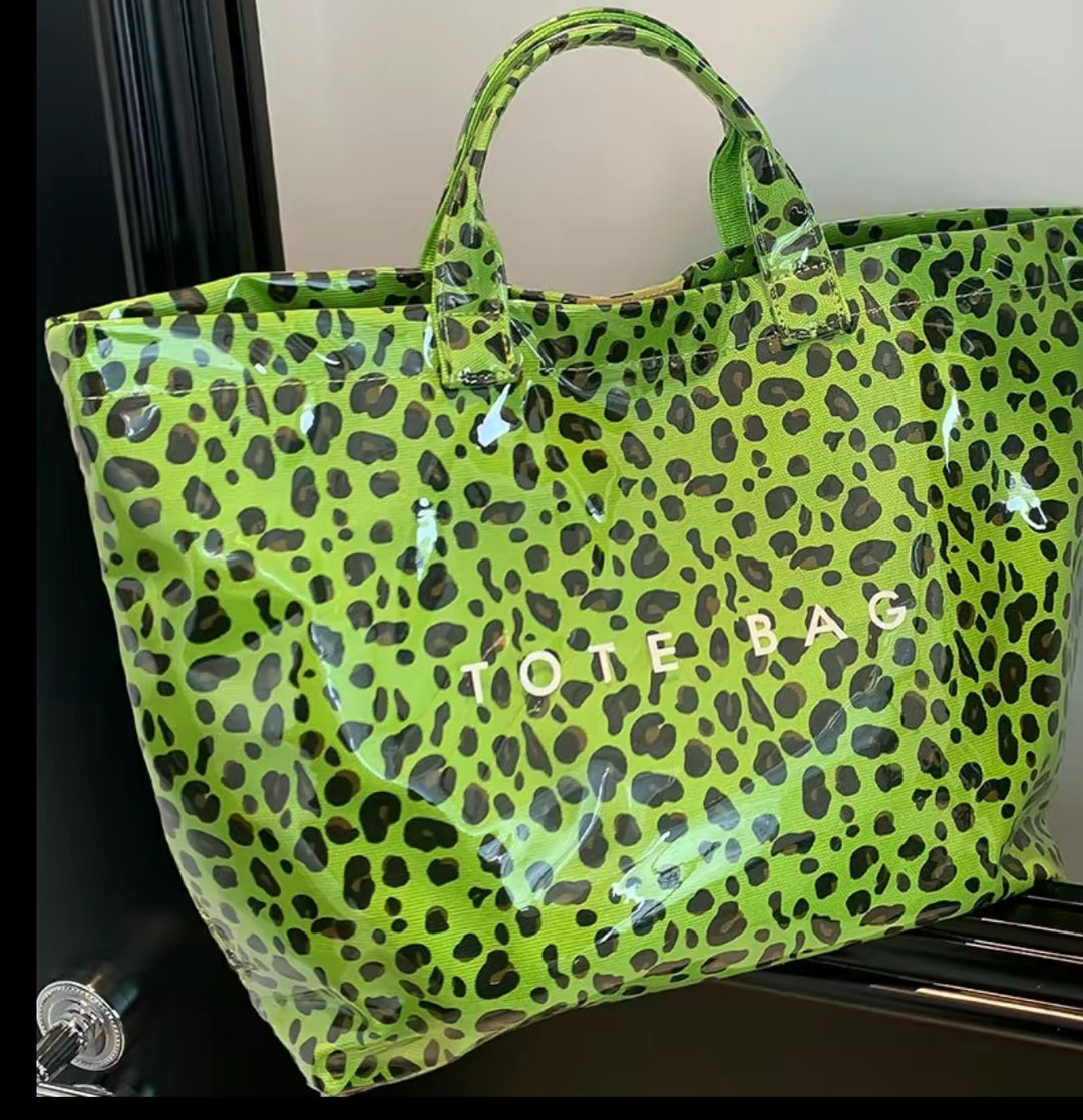 The Vintage Tote Bag: large, green with black leopard spots, white "TOTE BAG" print, two sturdy handles. Available in large size.