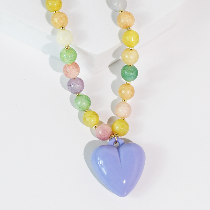 Necklace with round pastel beads, gold spacers, and a shiny purple heart pendant. Available in 2 colors. Sizes: not specified.