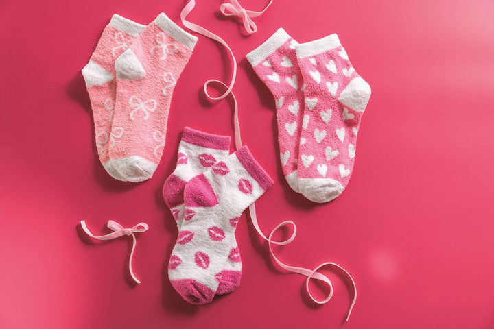 Three pairs of pink chenille socks with bow, heart, and lip patterns. Available in sizes S/M and M/L.