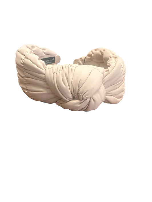 Padded light beige headband with a center twisted knot design. Available in small, medium, and large sizes.