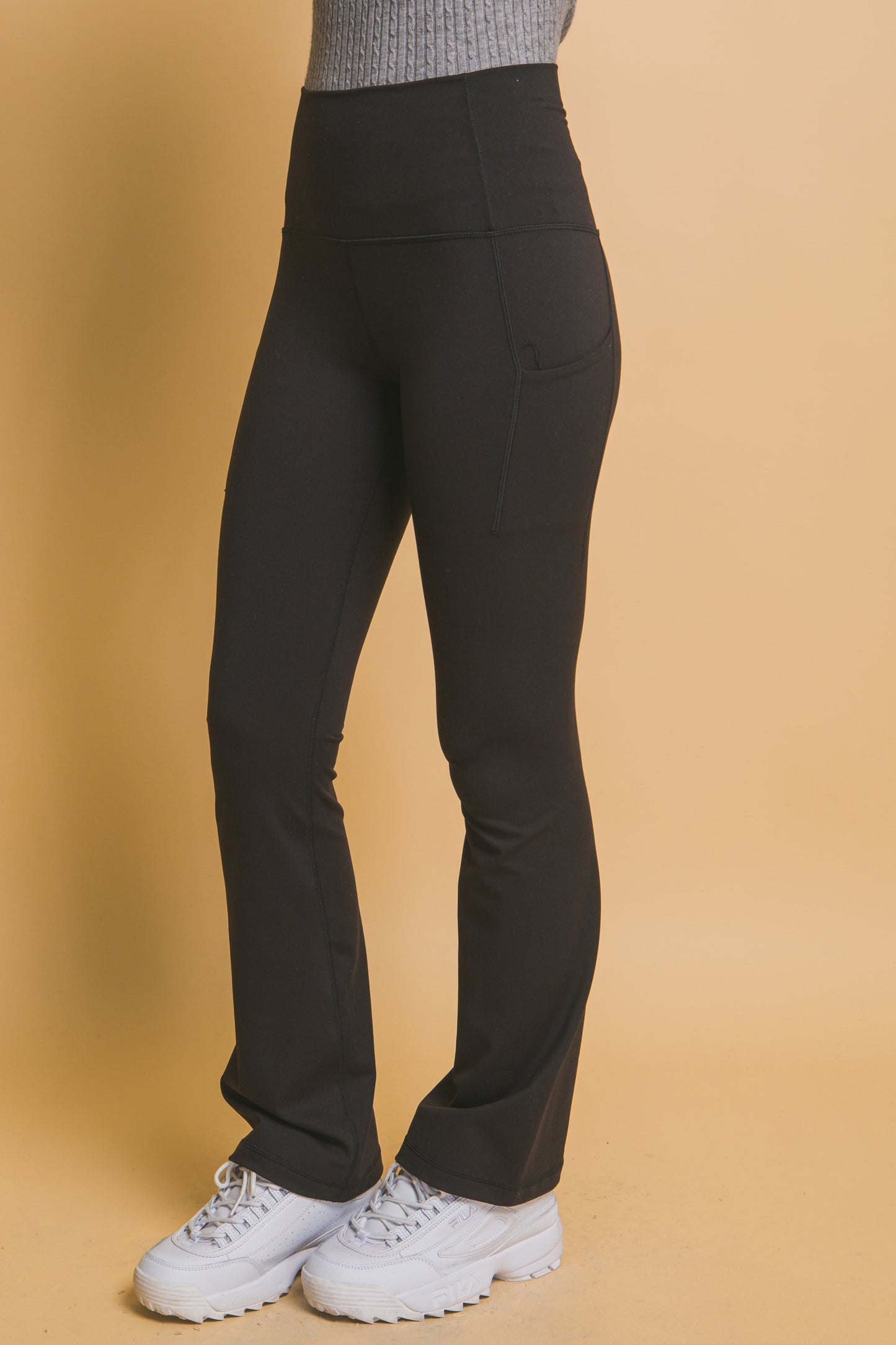 Black High-Waisted Flared Leggings with Side Pockets. Buttery soft texture, fitted style, subtle flare. Sizes available: XS, S, M, L, XL.