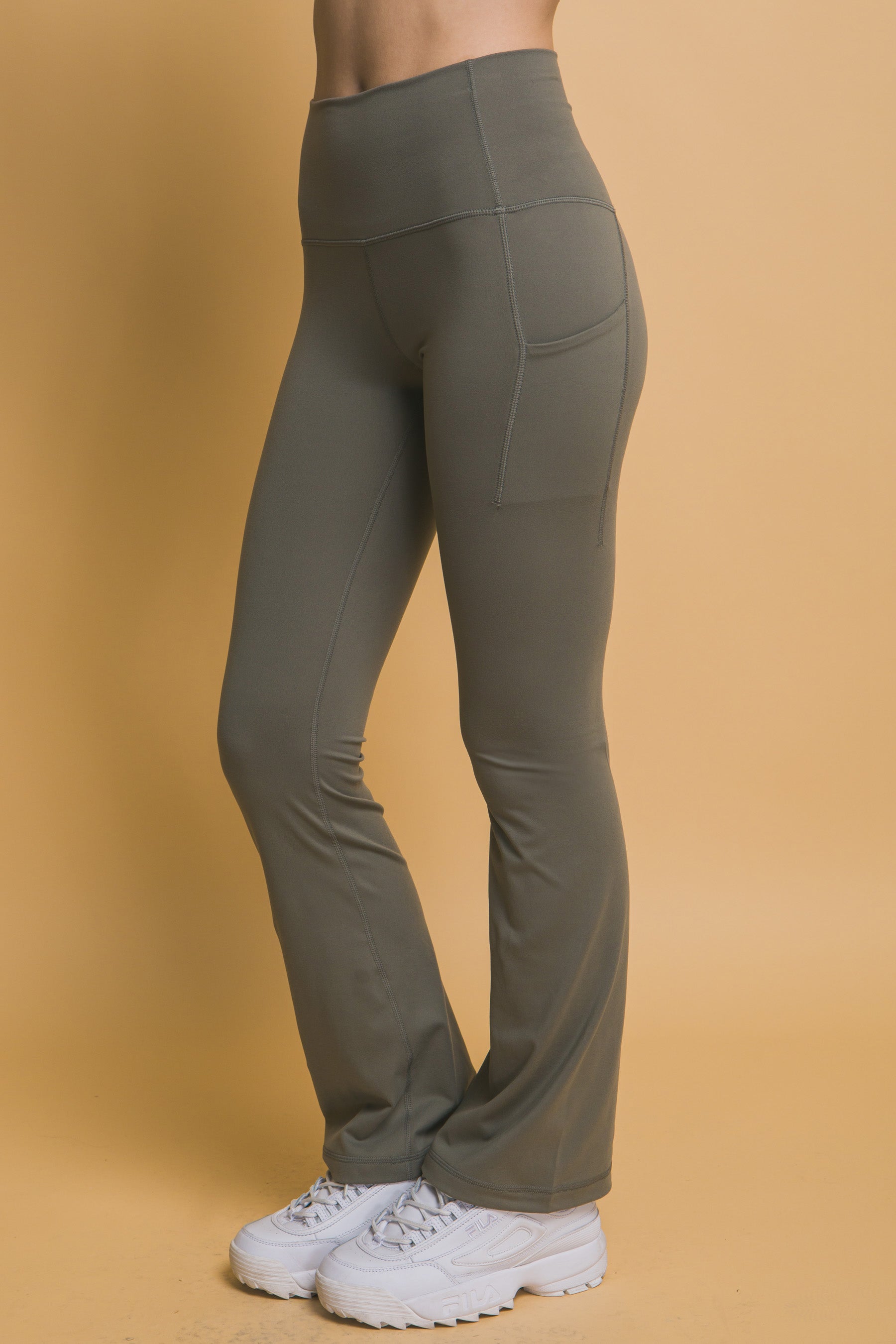 High-waisted flared leggings in buttery soft olive green with side pockets. Available sizes: XS, S, M, L, XL.