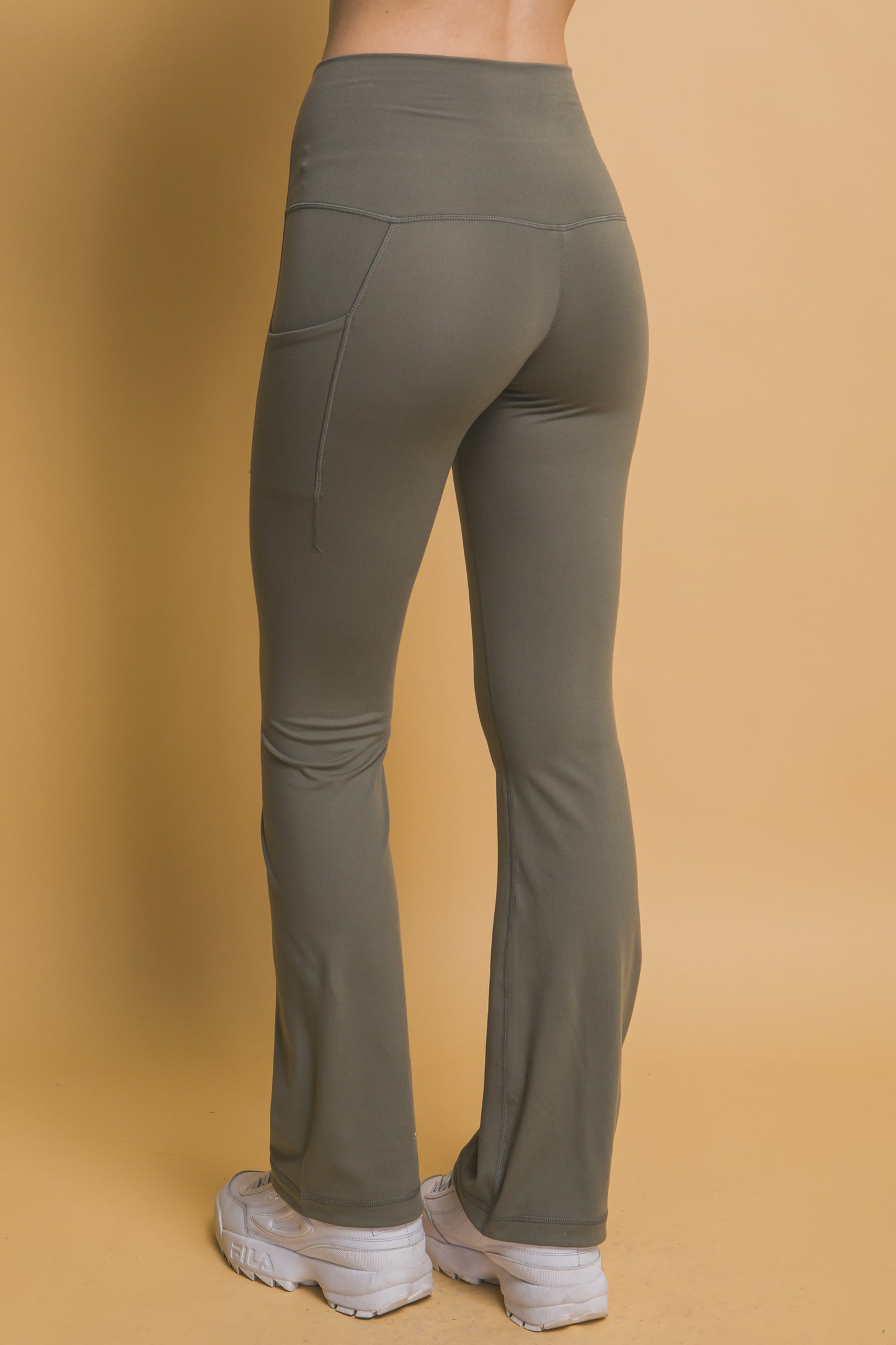 High-waisted flared leggings in olive green with buttery soft fabric and side pockets. Sizes available: XS, S, M, L, XL.