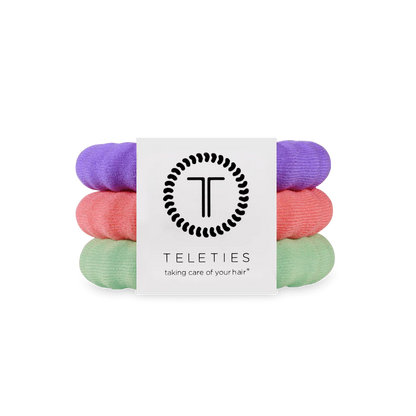 Three Teleties nylon hair ties in purple, pink, and mint green with logo label; available in small, medium, and large sizes.