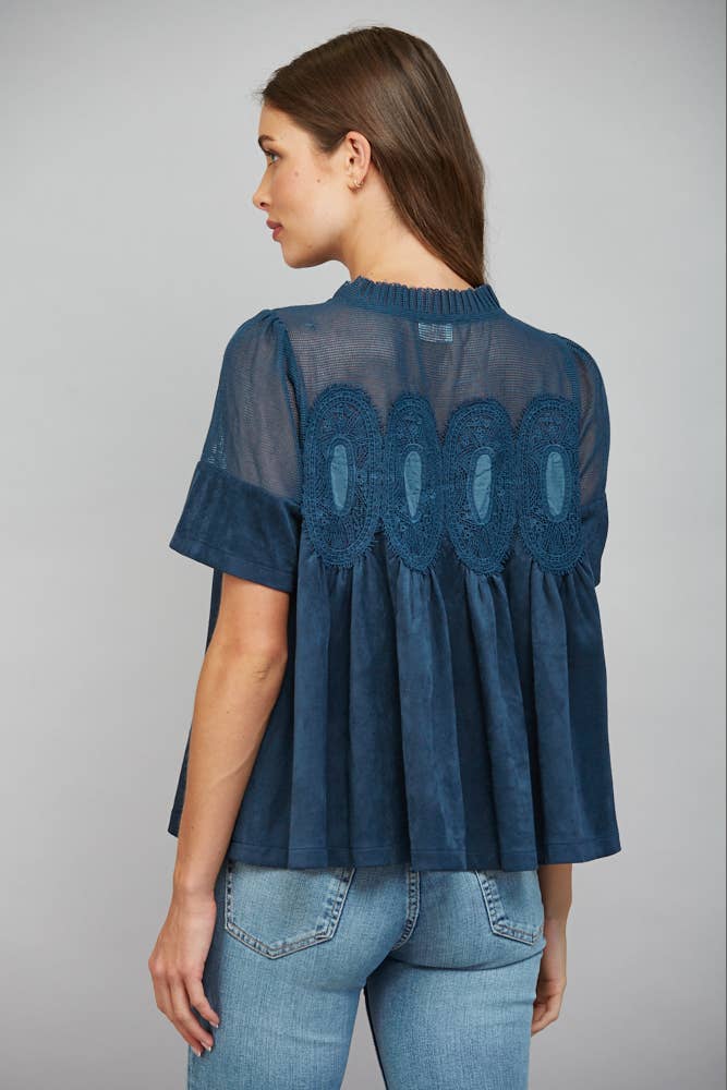 Teal blue short-sleeved top with sheer mesh upper panel, lace applique, faux suede, and pleated lower body. Size: S.