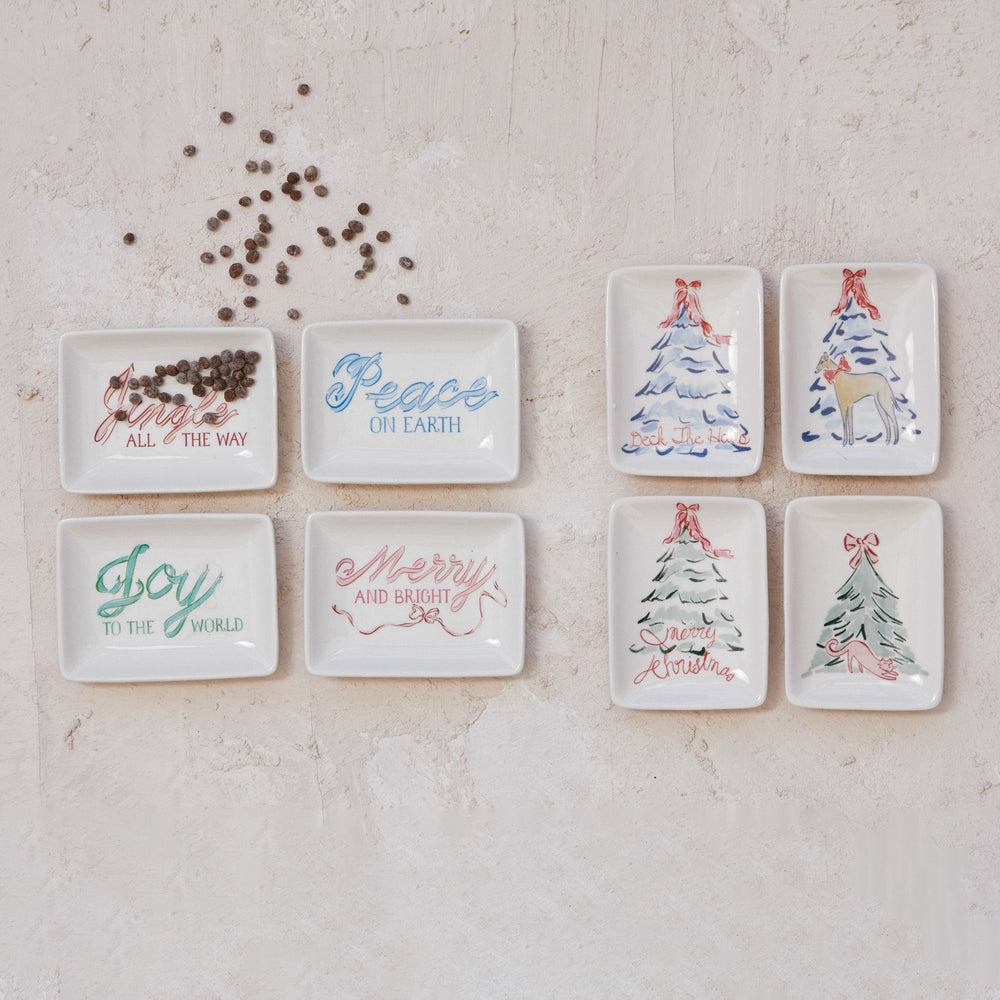 Eight rectangular stoneware dishes with Christmas tree and dog holiday motifs and seasonal text.
