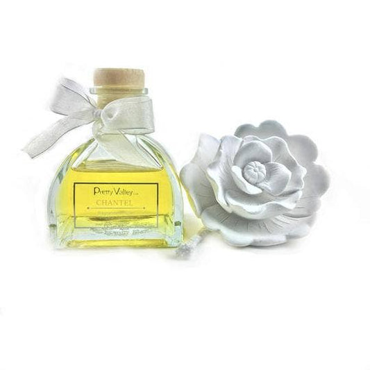 Glass bottle of yellow fragrance with wooden cap, white ribbon, white ceramic flower. Gardenia scent. Sizes: small, medium.