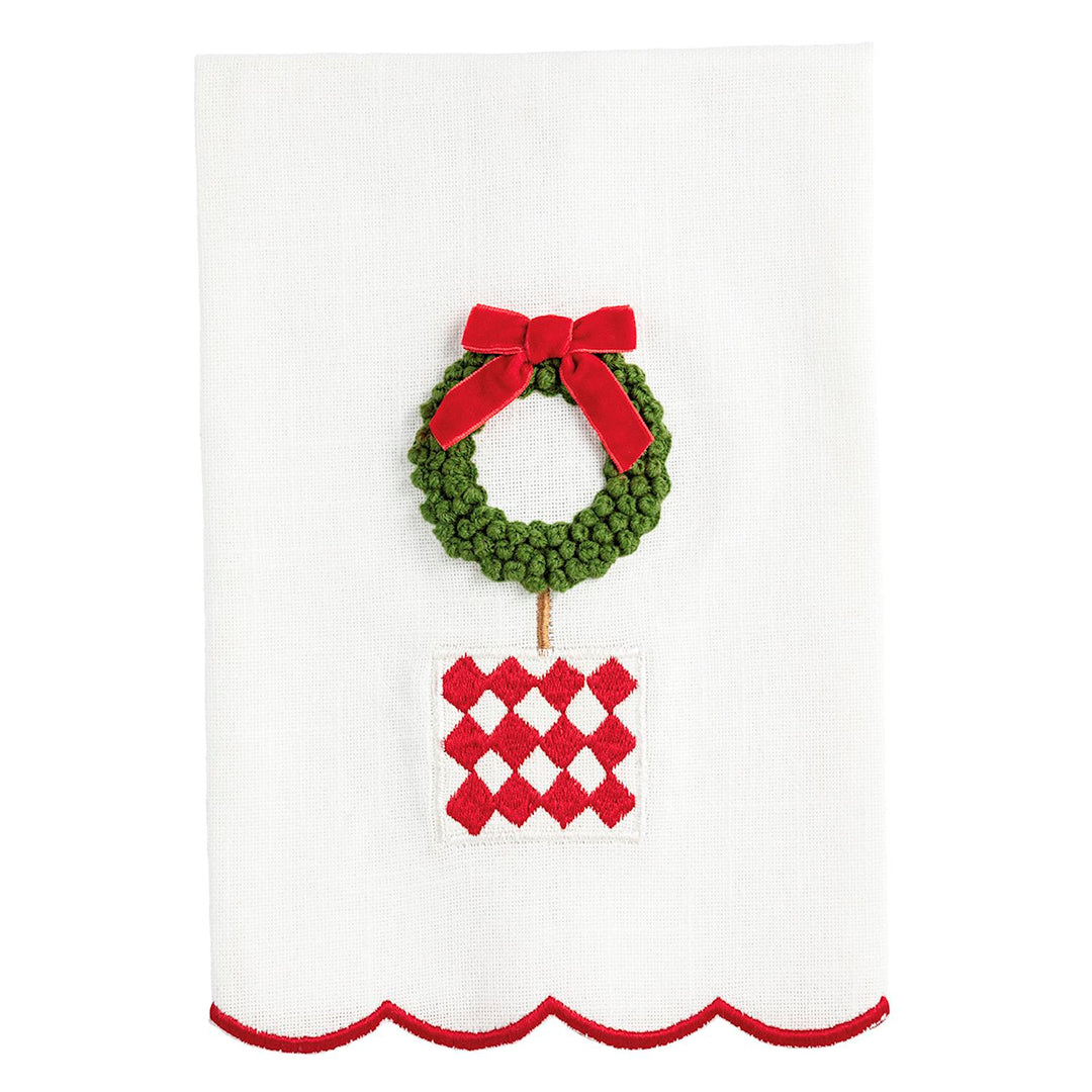 White Christmas topiary hand towel with scalloped red edge, embroidered wreath, red bow, and checkered pot.