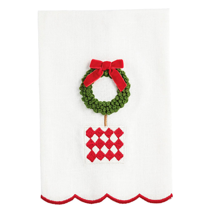 White Christmas topiary hand towel with scalloped red edge, embroidered wreath, red bow, and checkered pot.