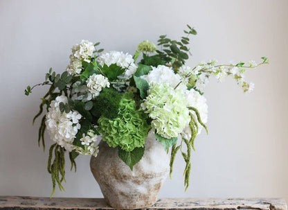 12.5" Real Touch Hydrangea with soft pink 6” bloom in rustic white ceramic vase, accented by leafy greens and artificial stems.
