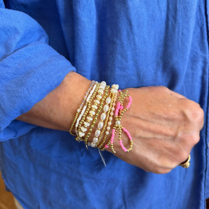 Gold beaded bracelets with gold, white, pink, and pearl accent beads. Available in S, M, L sizes.