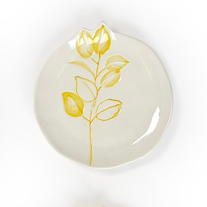 Round white ceramic plates with yellow floral design, uneven edges. Minimalist. Available in 6-inch and 8-inch sizes.