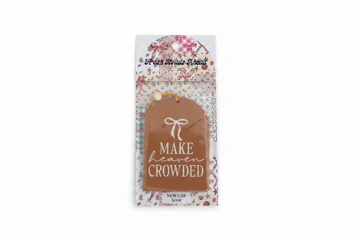 Brown tag-shaped air freshener with white bow, "MAKE HEAVEN CROWDED" text; NEW CAR scent. Sizes available: not specified.