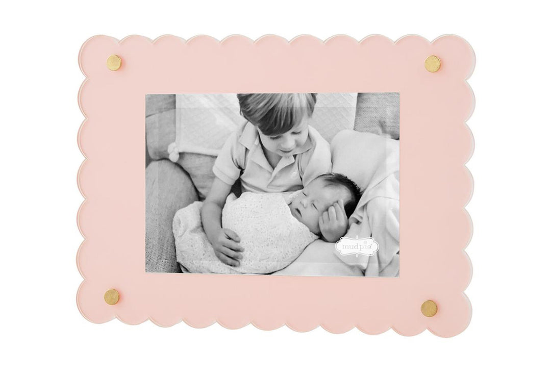 A black and white photo of a young boy gently touching a baby&