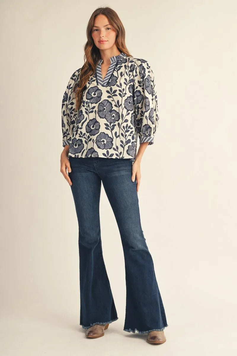 Bonnie Ruffle Floral Blouse with blue floral patterns, available in sizes XS–XL.