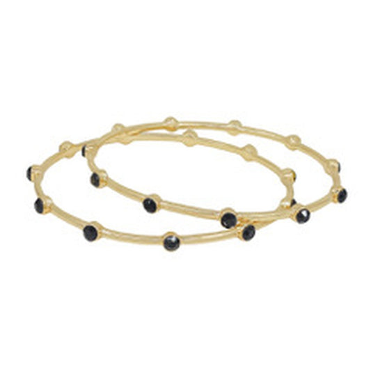 The Kelse Black Bracelet: two gold bangles with black stones and round gold accents. Available in S, M, and L sizes.