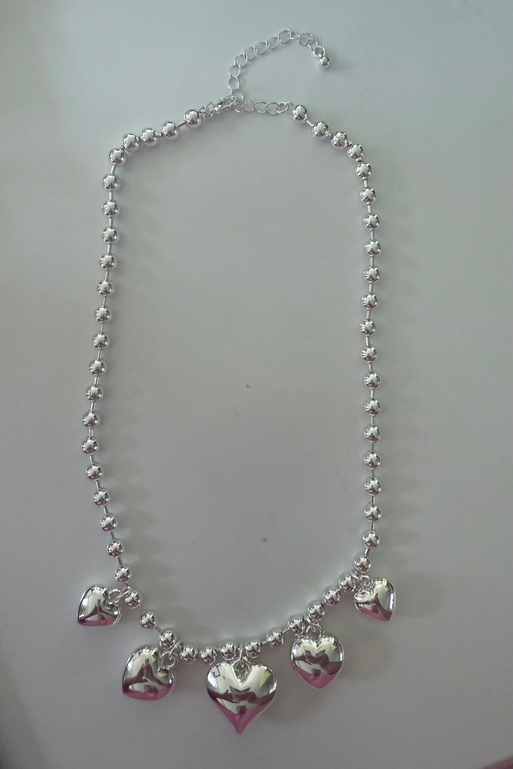 The Heart Ball 18k Gold/Silver Necklace has round beads, five heart pendants, adjustable chain. Available in multiple sizes.