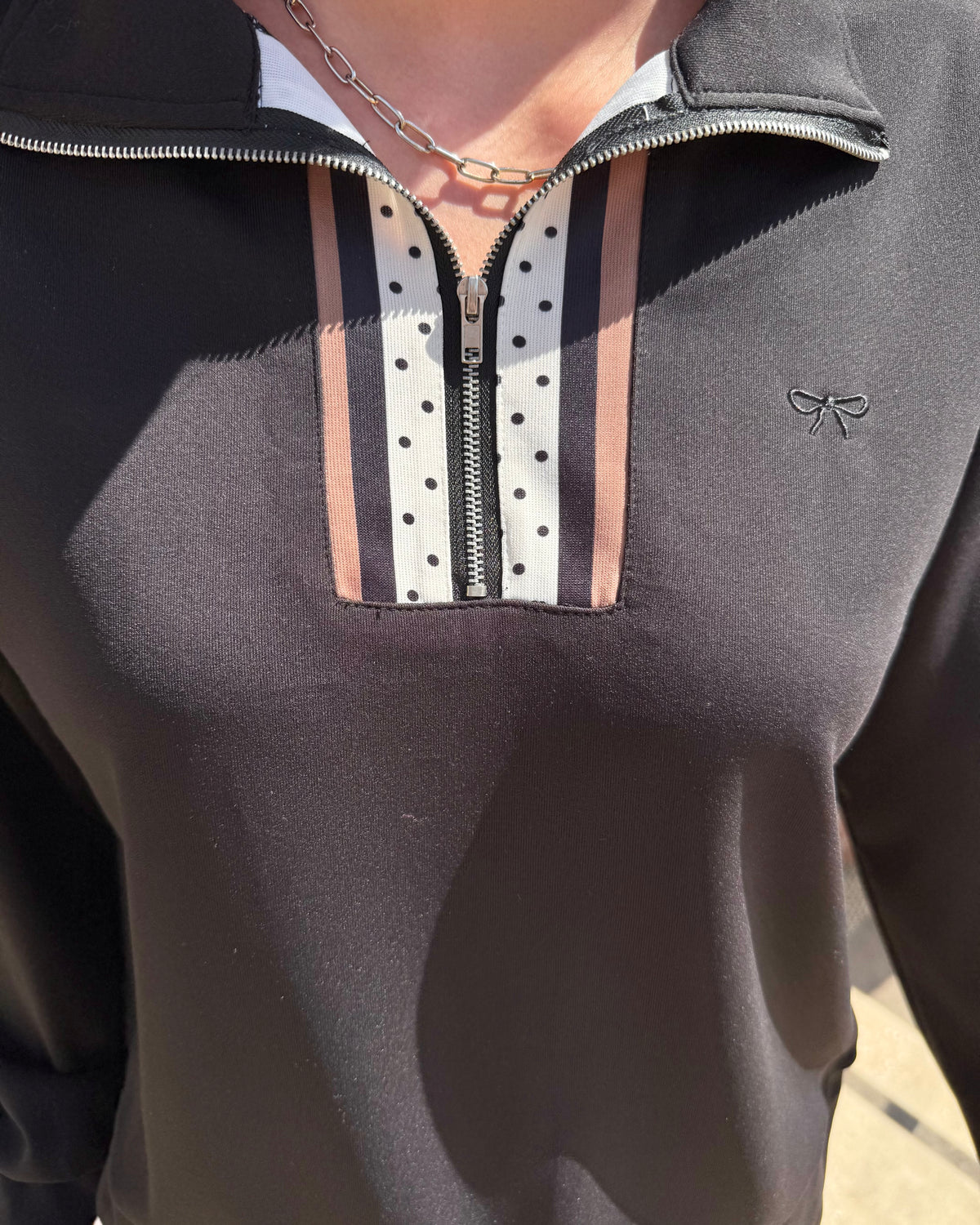 Margot Polka Dot Striped Quarter Zip features white and brown stripes with black polka dots and a small bow logo on the left. Available in sizes XS–XL.