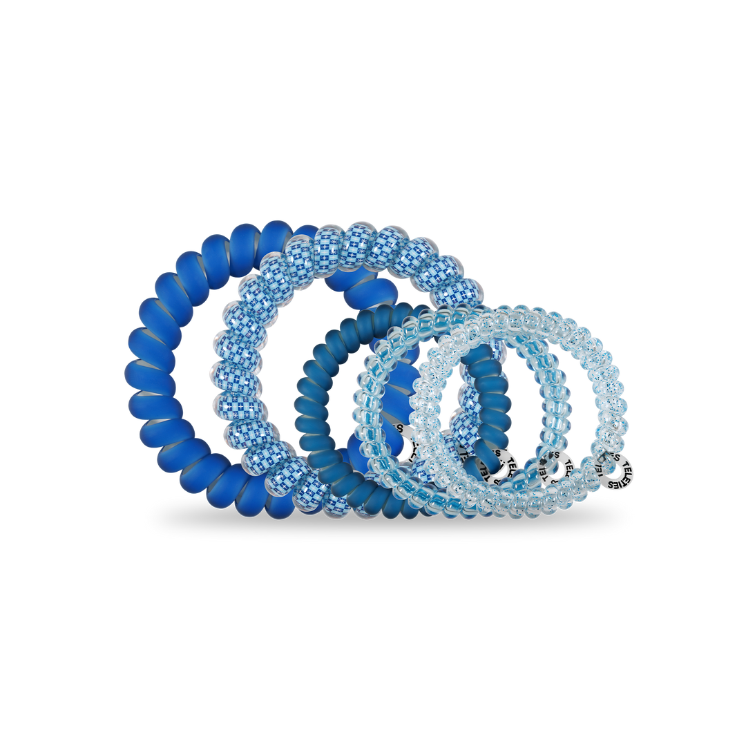 Four blue Hanukkah-inspired spiral hair coils in assorted sizes, worn as hair ties or bracelets. Sizes: small to large.