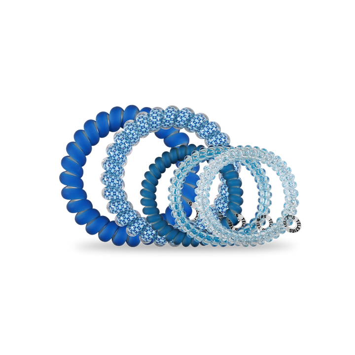Four blue Hanukkah-inspired spiral hair coils in assorted sizes, worn as hair ties or bracelets. Sizes: small to large.