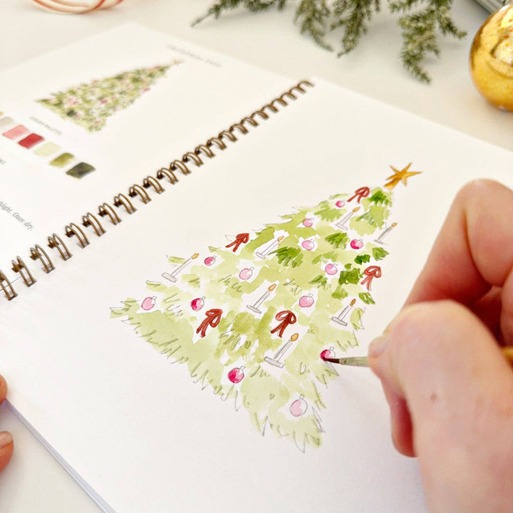 A Nutcracker watercolor workbook with painted red ornaments.
