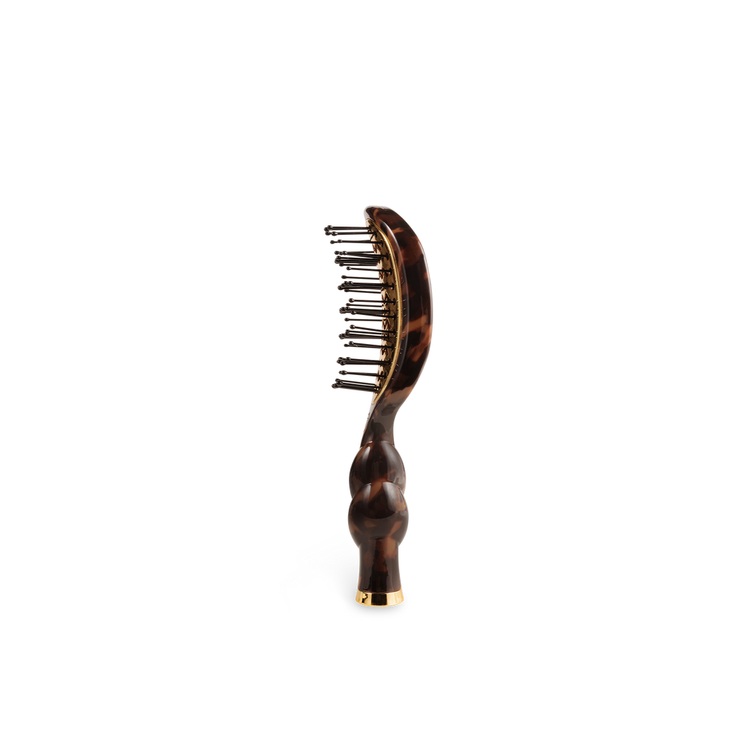 The Mini Vented Brush | Tortoise has a curved handle, metal bristles, and is available in mini size.