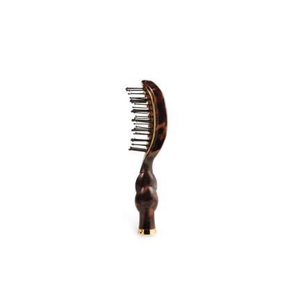 The Mini Vented Brush | Tortoise has a curved handle, metal bristles, and is available in mini size.