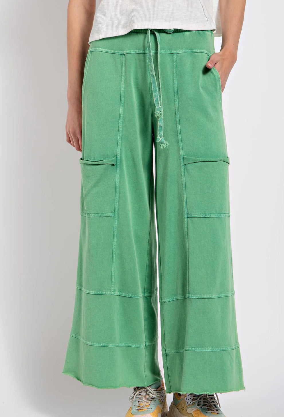 Bright green wide-leg terry knit bottoms with front pockets, drawstring waist, and stitching details. Available sizes: S, M, L.