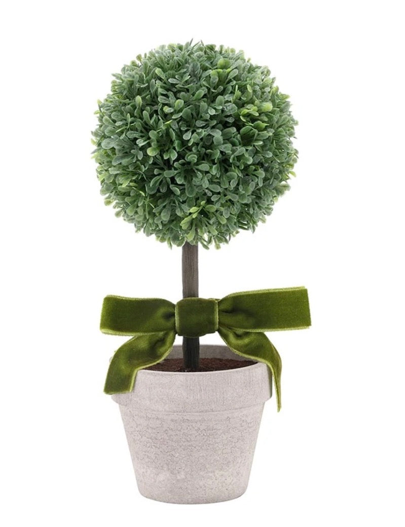 Compact faux topiary with a round ball of green leaves, straight trunk, green velvet bow at the base, and simple pot. Available in various sizes.