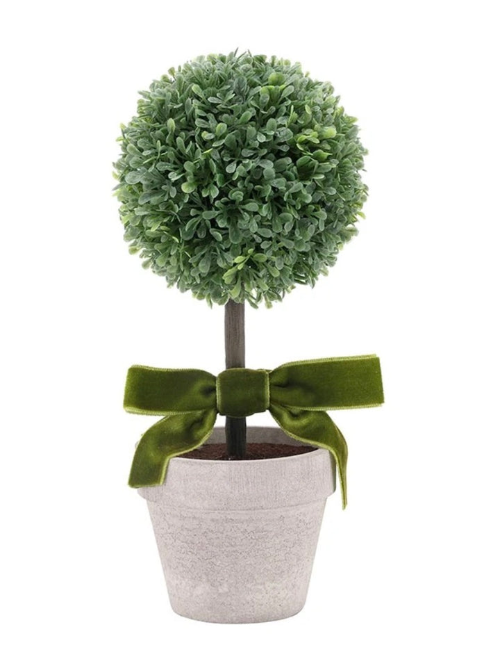 Compact faux topiary with a round ball of green leaves, straight trunk, green velvet bow at the base, and simple pot. Available in various sizes.