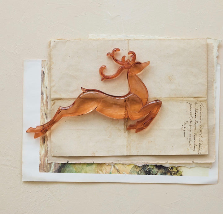 Translucent amber-colored leaping acrylic deer ornament.