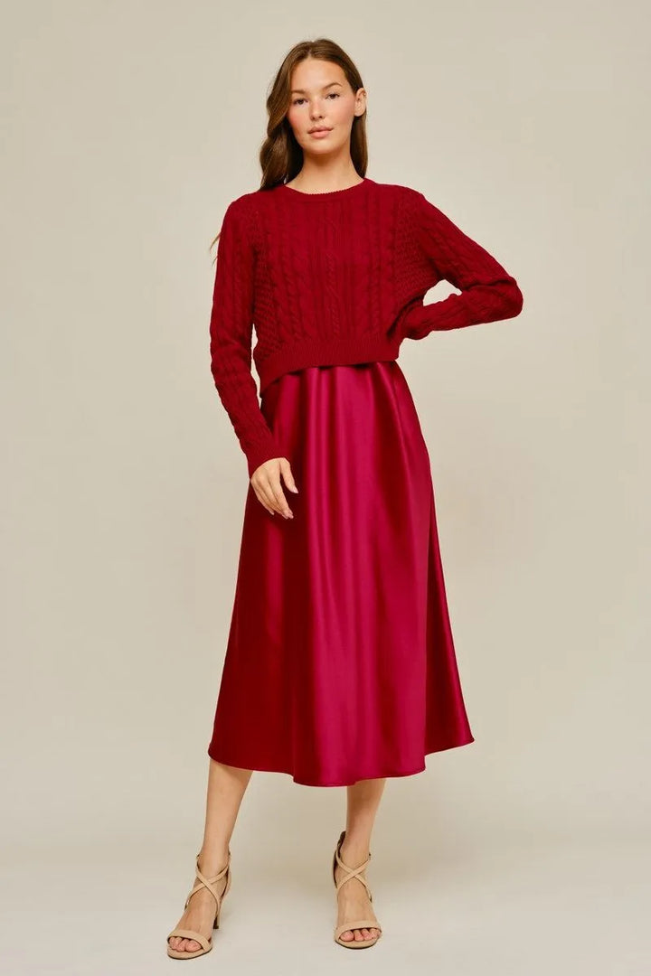 Maroon long-sleeved cable-knit sweater and matching satin midi dress. Sizes available.