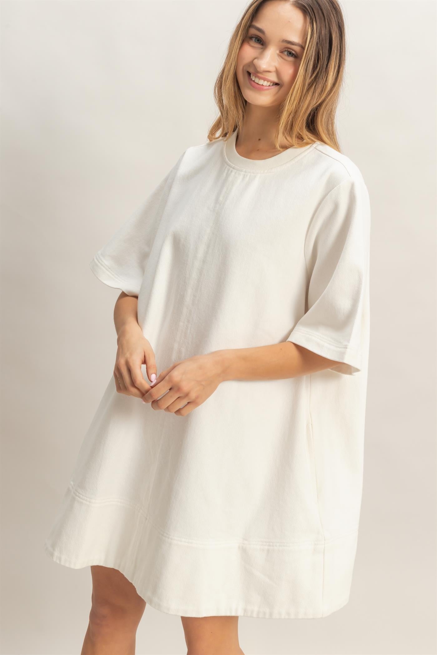 Loose-fitting, short-sleeved white crew neck denim tunic. Available in sizes XS to XL.