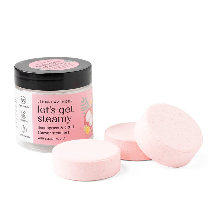 Jar of "Let’s Get Steamy Shower Steamers | Lemon Lavender" with three pink round steamers; sizes: not specified.