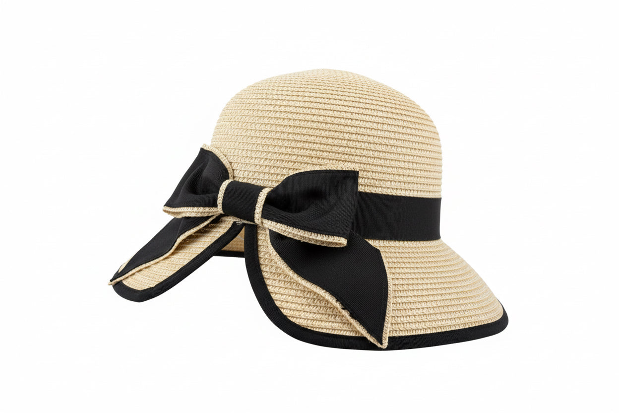 Beige woven sun hat with wide brim, black ribbon band and side bow. Available in S, M, L.