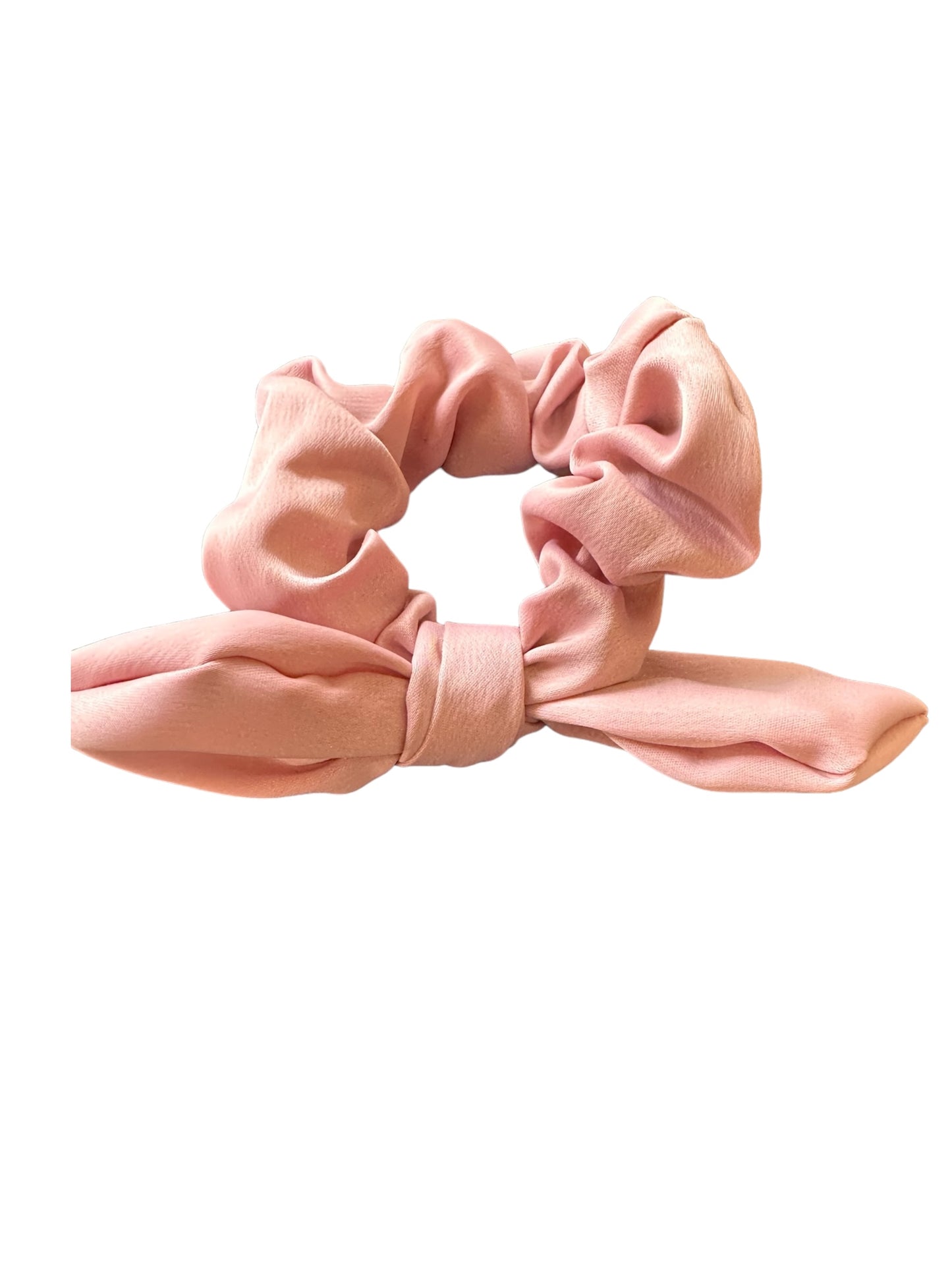 Pink fabric scrunchie with a cute bow design. Gathered ruffle fabric forms an elastic hair tie with a decorative bow at the base. Available in one size: fits all. Perfect for ponytails or buns.