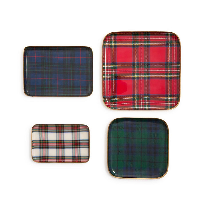 Four rectangular tartan metal trays with gold-toned rims in red, green, blue, and white plaid.