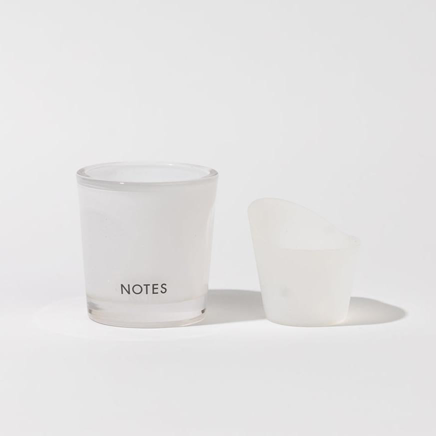 White frosted "NOTES" candle jar with angled translucent lid; available in multiple sizes; refillable starter glass.