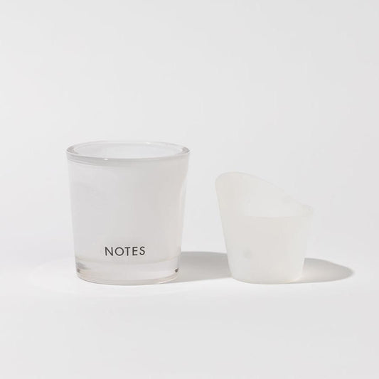 White frosted "NOTES" candle jar with angled translucent lid; available in multiple sizes; refillable starter glass.